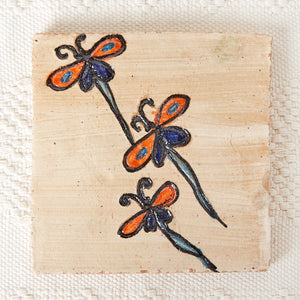 Dessous de plat en argile peinte avec 3 libellules orange, bleues et turquoise