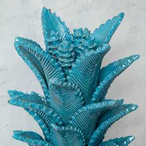 Elongated pineapple made of glazed clay turquoise leaves